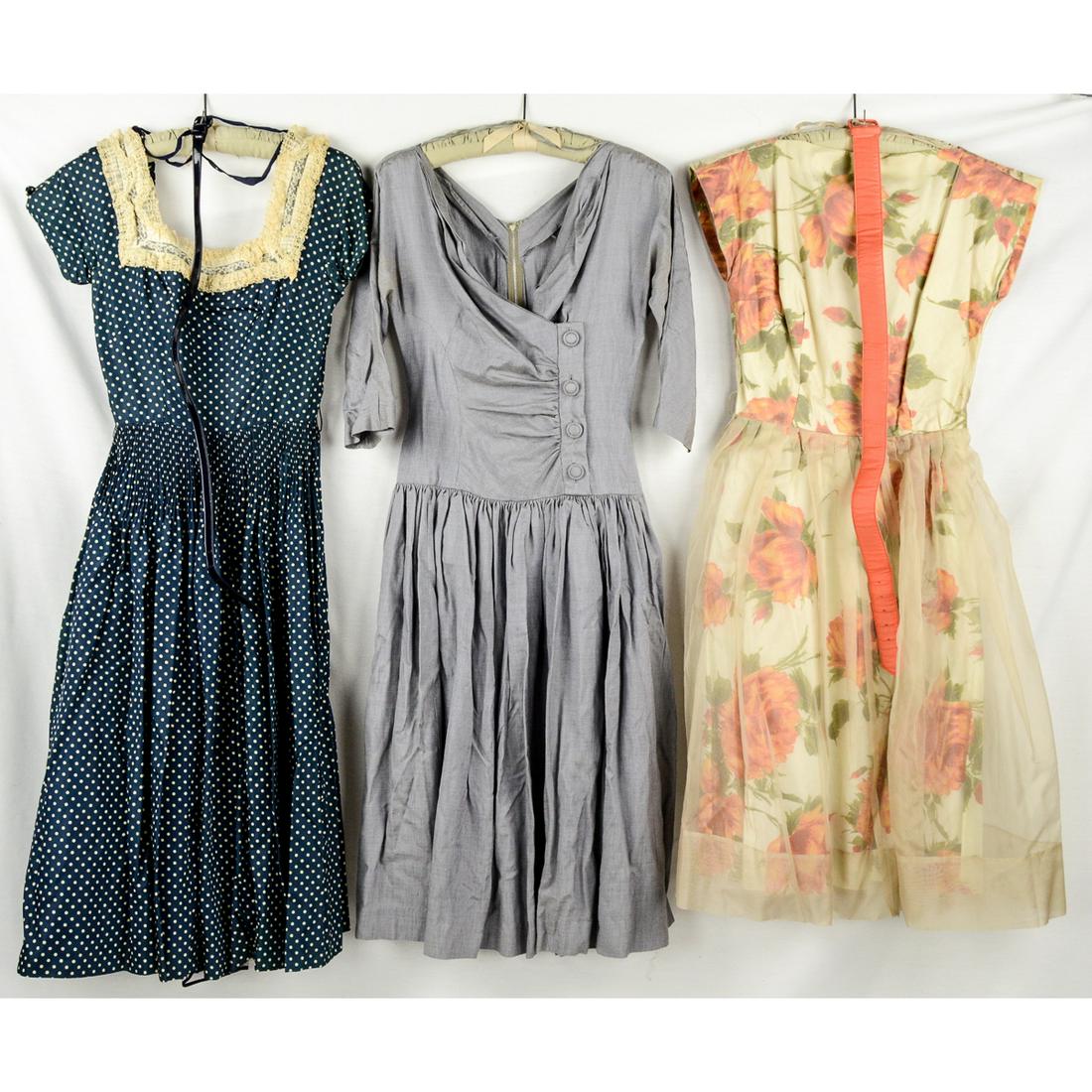 3 1950s Full Skirted Party Dresses: Navy blue swiss dot short sleeved, square collared dancing dress. Hundreds of pleats at the waist. Taffeta material with miles of skirt. Dress has its own crinoline underskirt. Comes with a patent lea