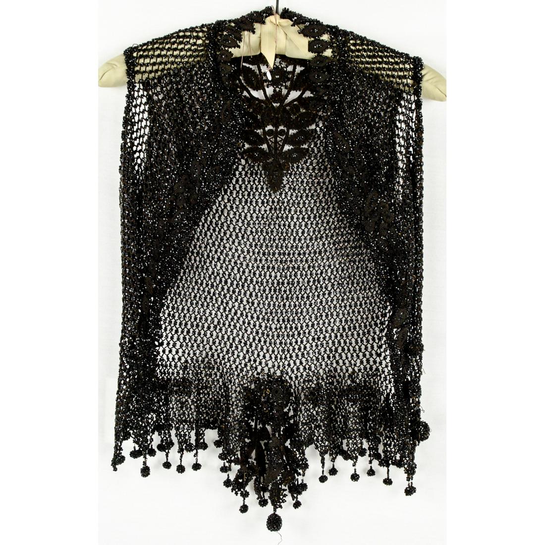 Victorian Jet Black Glass Bead Vest: In excellent museum quality condition. Crocheted diamonds climb up the back of the neck of this fine Victorian vest. Beaded ball trim along the bottom. Metal hook and eye closure up the front. Very he