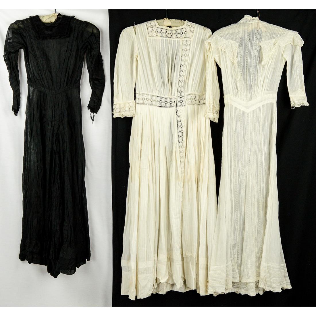Early 1900 Study in Black and White: White cotton crepe, ice cream social dress in very good condition, lace trim throughout, 24" waist, hanger repair needed. Black gauze long sleeve dress, in very good condition, 21" waist, possible mou