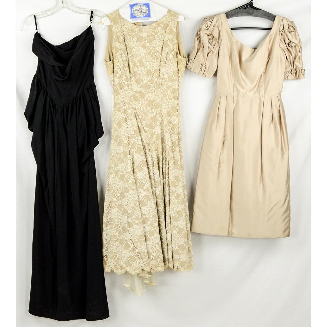 3 1950s Ladies Formalwear: Beige satin full skirted dress, decorative roses on short sleeves, back metal zipper, 24" waist, in excellent condition. Black strapless long formal with side boning, small holes and some fading, 26" 