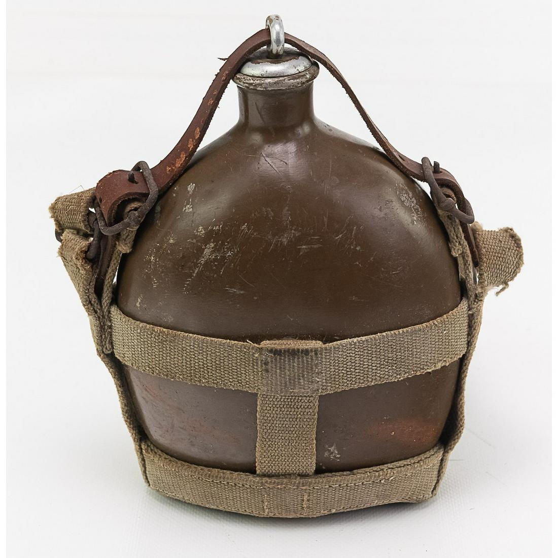 1942 WWII Japanese Canteen w/Stopper and Webbing: This canteen is dated Showa 17, which is 1942 and has its original canvas and leather webbing, and Type A stopper. It has most of its paint. There is some hand written Japanese on the webbing.