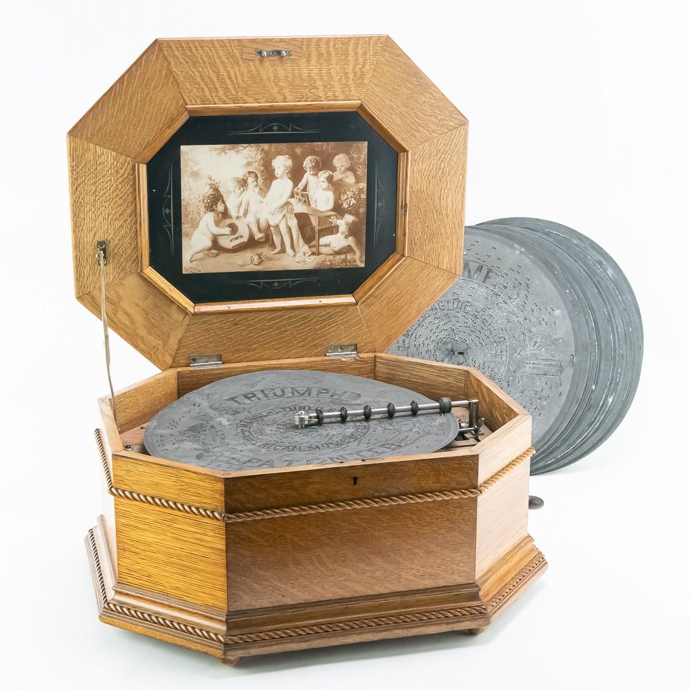 American Music Box Co 15 3/4" Music Box w/15 Discs: This is an attractive quarter-sawn oak, octagon cabinet featuring rope twist molding on all sides, there is a large chip on the lid (see photo), reproduction Polyphon trademark graphics, a new plywood