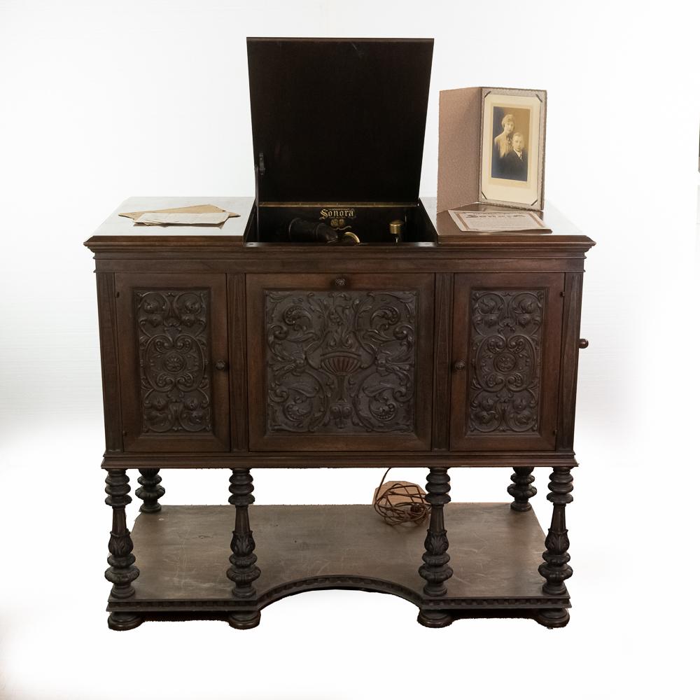 Sonora Italian Renaissance Period Cabinet Lowboy: This massive American Walnut Sonora Period Cabinet Lowboy in very good condition with ornate carvings in the front three doors and legs. Has an elaborately carved wooden tone arm. Also equipped with a