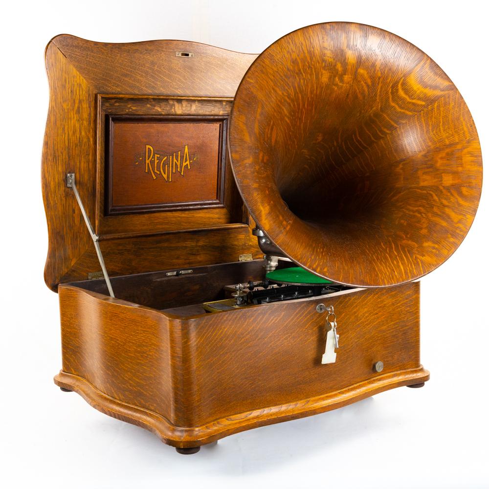 Reginaphone Style 139 Disc Music Box w/ Wood Horn: This large impressive machine in its serpentine oak cabinet has been professionally refinished some time ago. Has nice color and good patina in overall good condition and presents well. The short bed