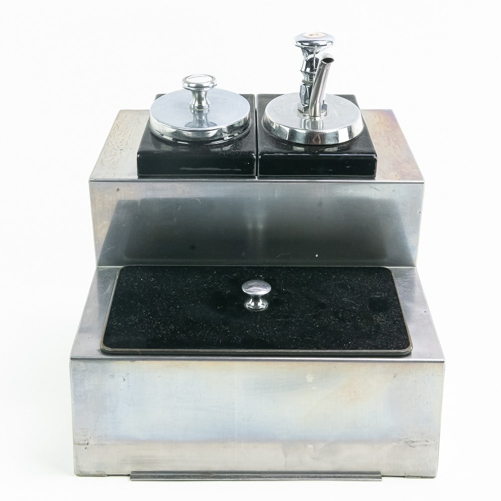 Dipper Well - Soda Fountain: Kelvinator model K syrup and crushed fruit dispenser. Stainless steel is in good condition. One reservoir has a chip on the back corner. Pump and ladle are both in good condition. The base is 11 3/4" 