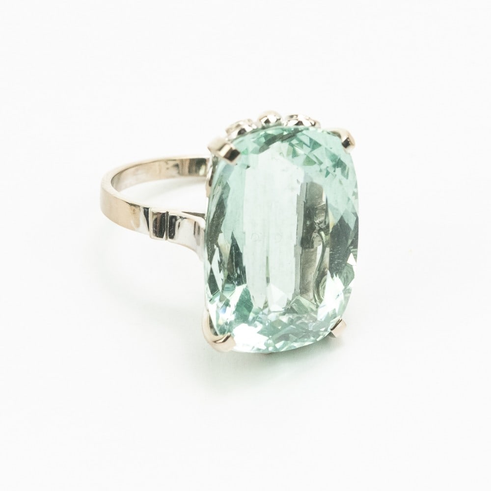 18K White Gold Ladies Cocktail Ring: 18k white gold ring set with 1 greenish quartz oval brilliant cut stone measuring 21.29 x 15.28 x 10.0mm, approximate weight 18.54 carats. Approximate weight 6.4 dwt.. Approx. ring size: between 7.25 
