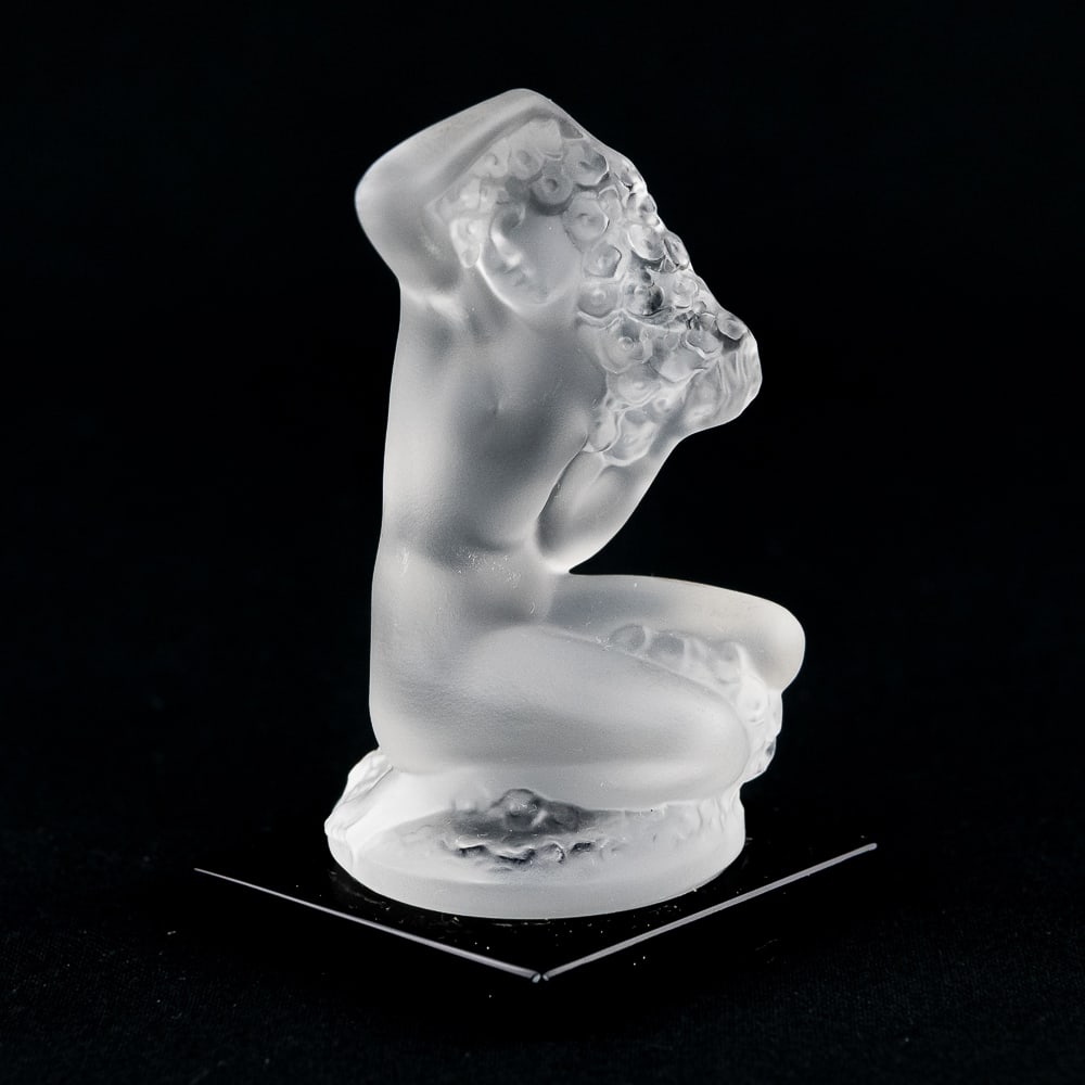 Lalique France Nude Woman Frosted Statuette: Lalique France Floral small statuette nude woman frosted on black ceramic base. Small frosted crystal statuette of a mysterious ethereal nude woman seated mermaid style, a nude female figure with flow