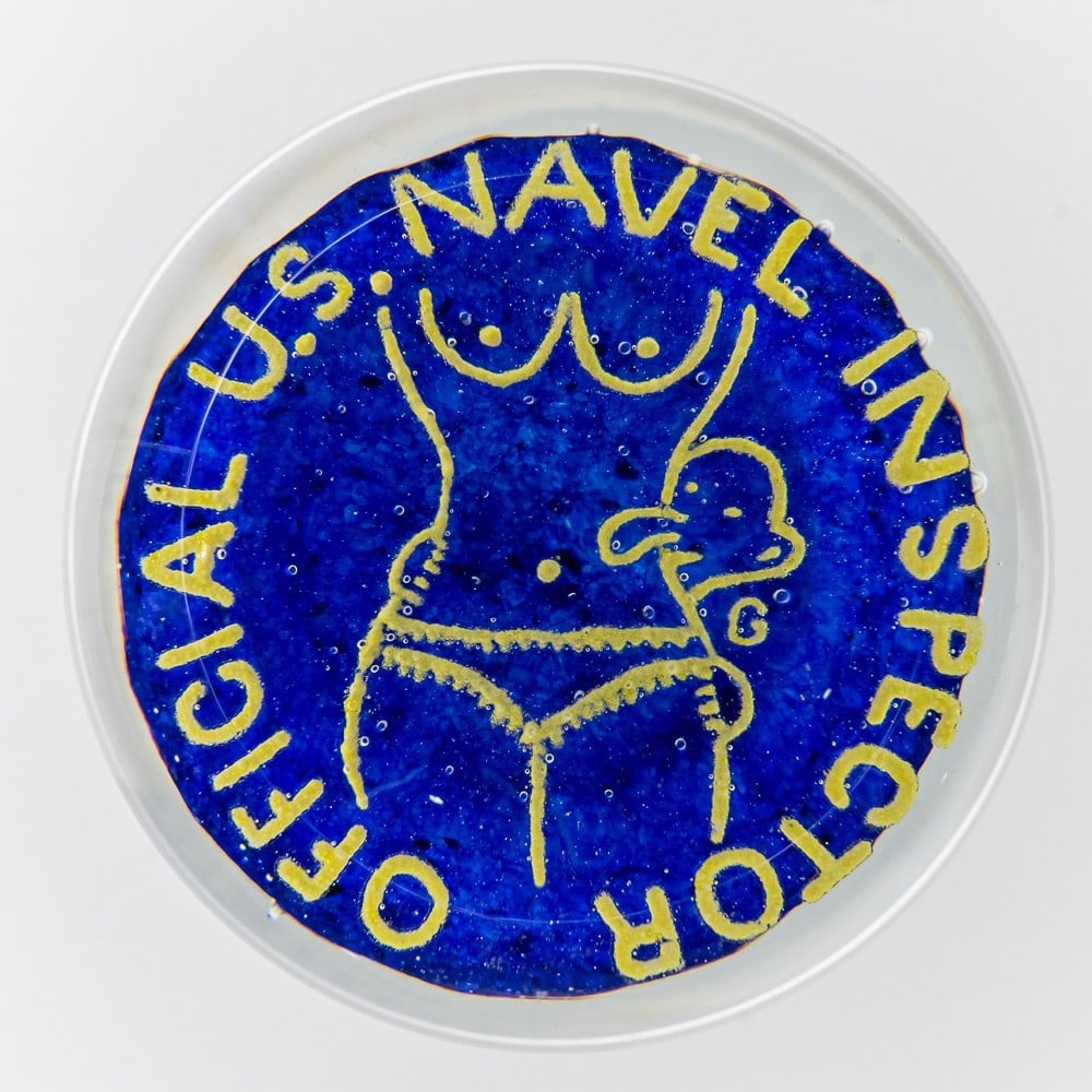 Glass Navel Inspector Paper Weight: Glass U.S. Navel Inspector Official Paperweight, in great condition with no noticeable scratches or defects. Has blue cobalt bottom with display of a female body, with yellow text that reads "Official