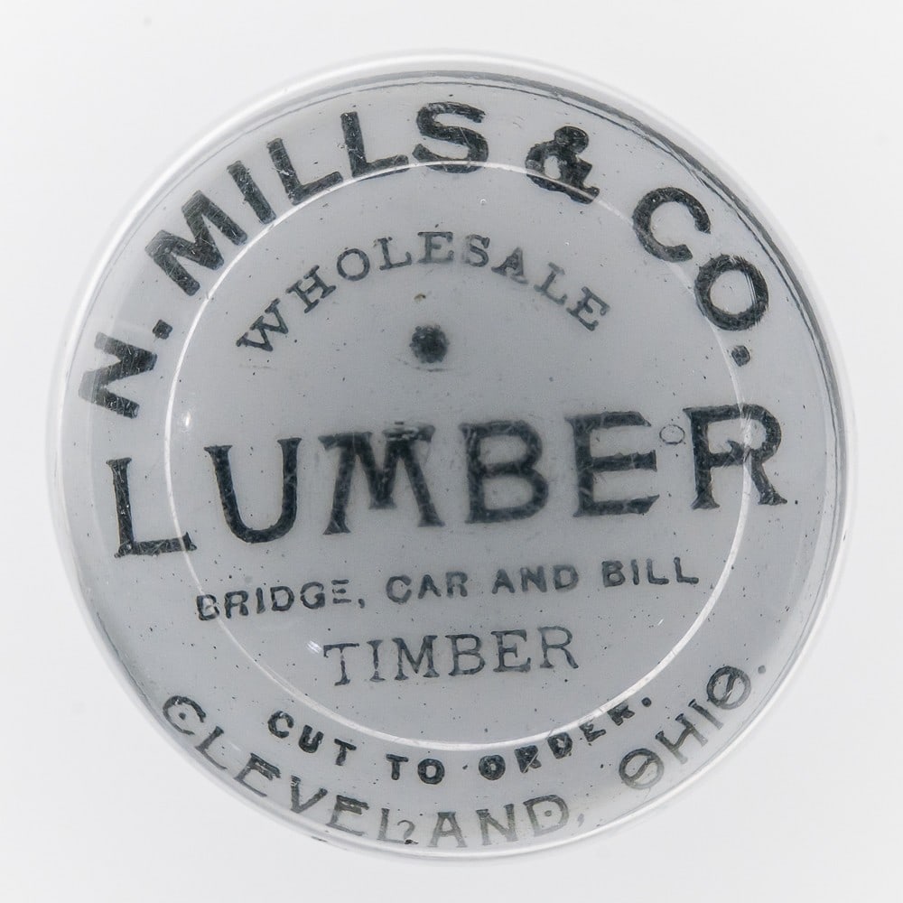 Glass N. Mills & Co. Advertising Paper Weight: Glass N. Mills & Co. Cleveland, Ohio Paperweight, in great condition with signs of light wear noted. Has white bottom with black "Wholesale Bridge, Car and Bill Timber" text. Measures approx. 2"H X 3"