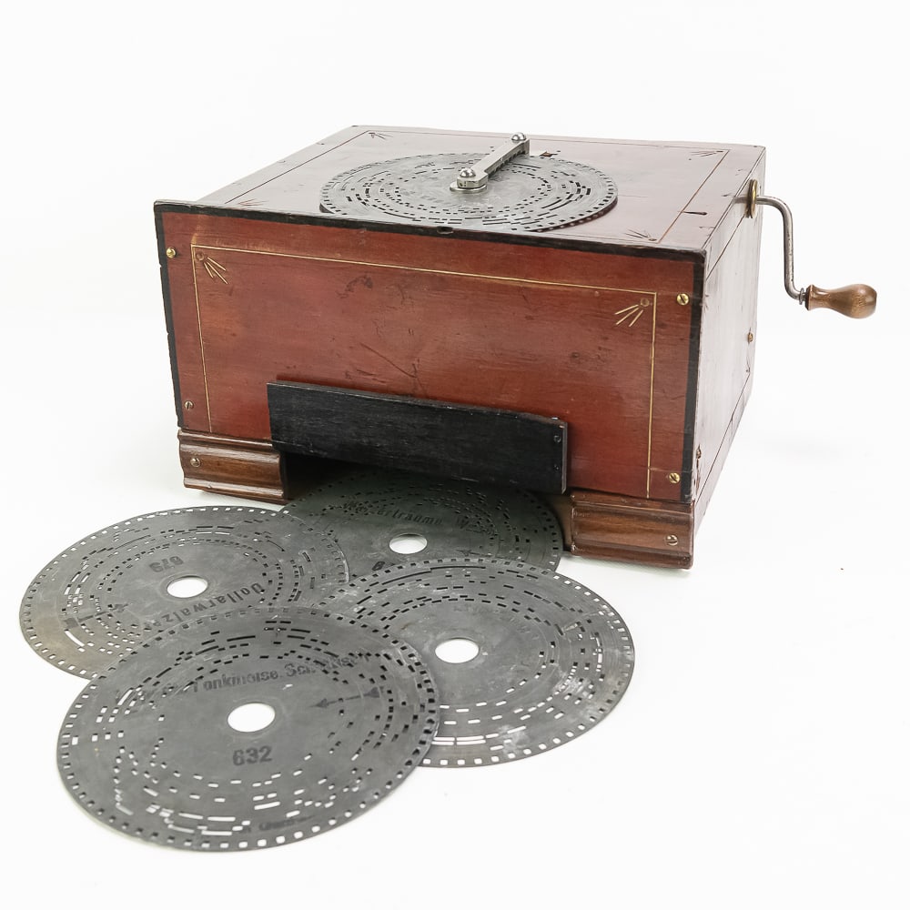 Small Metal Disc Crank Organette: Small 14 note German made organette using 6.5" zinc discs (5 included). In overall good condition. Cranks and plays lightly. Bellows will probably need a rebuild. Wood cabinet measures 11.25" wide, 10