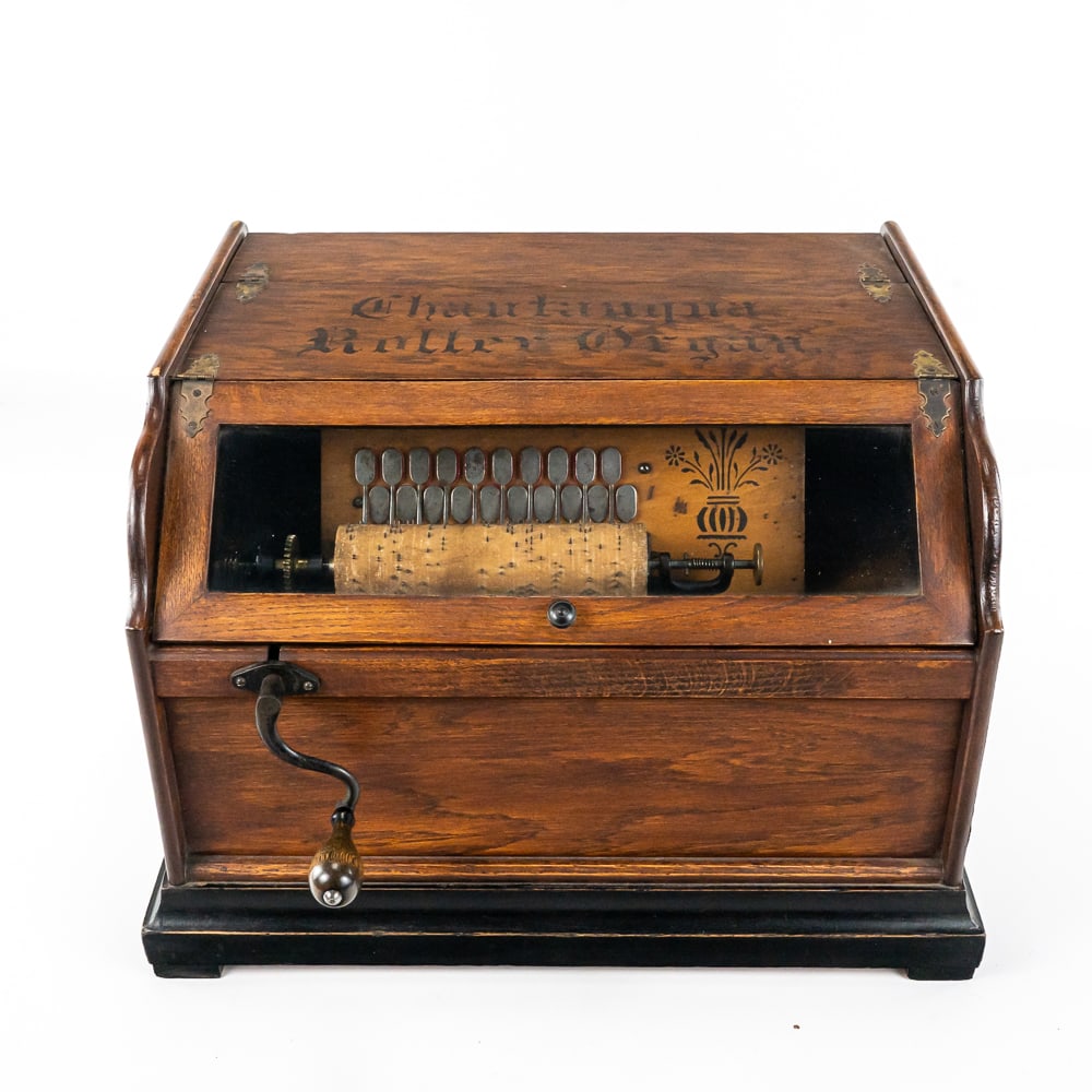 Chautauqua Roller Organ: This machine in its oak cabinet has its original finish and stenciling in good original condition with the usual wear. The cabinet features hinged top covers. The smaller one which is for volume and e