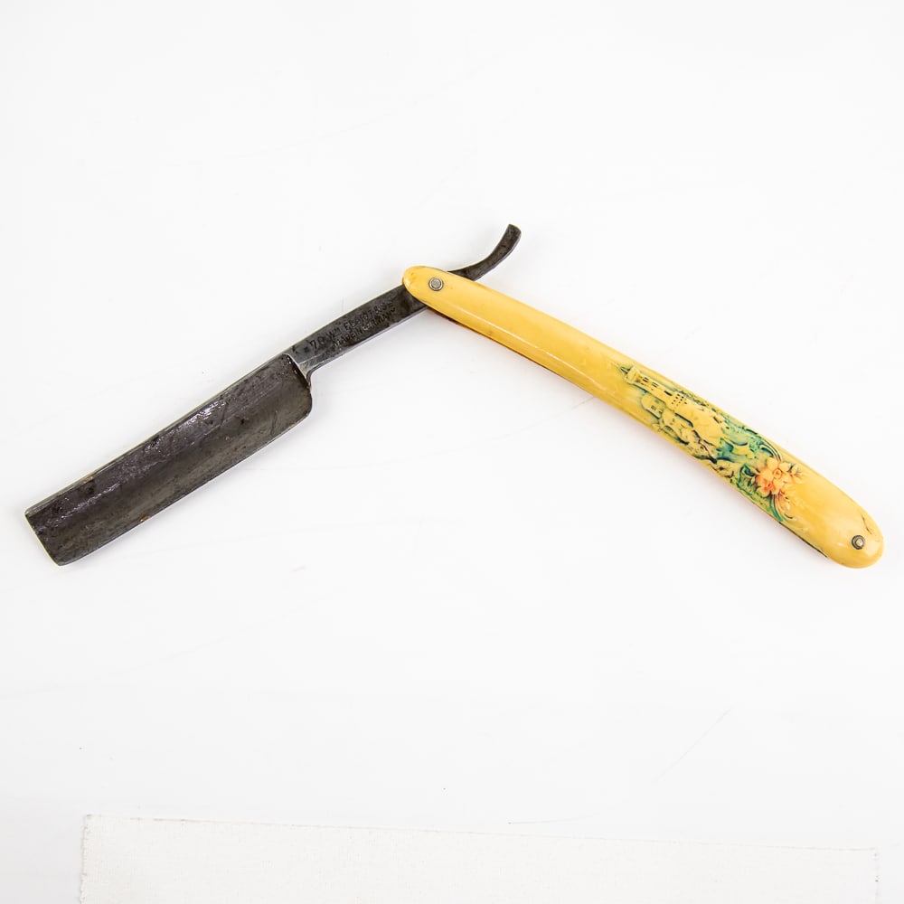 WM Elliot & Co 70 Straight Razor: Vintage Straight Razor "70" by WM Elliot & Co. Has yellow celluloid scales with embossed flowers and castle, with a blank face. Tang reads "70 WM Elliot & Co Made in Germany" and reverse is blank. Has