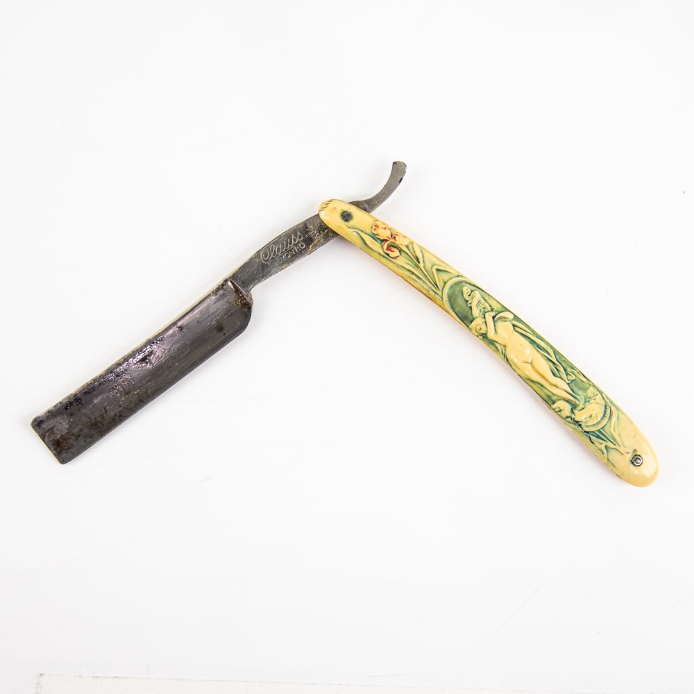 Clauss 70X Nude Straight Razor: Vintage Straight Razor 70X by Clauss. Has cream off-white celluloid scales with embossed nude woman with blue colored background, with a blank face. Tang reads "Clauss Fremont. O." and vertical "70X" 