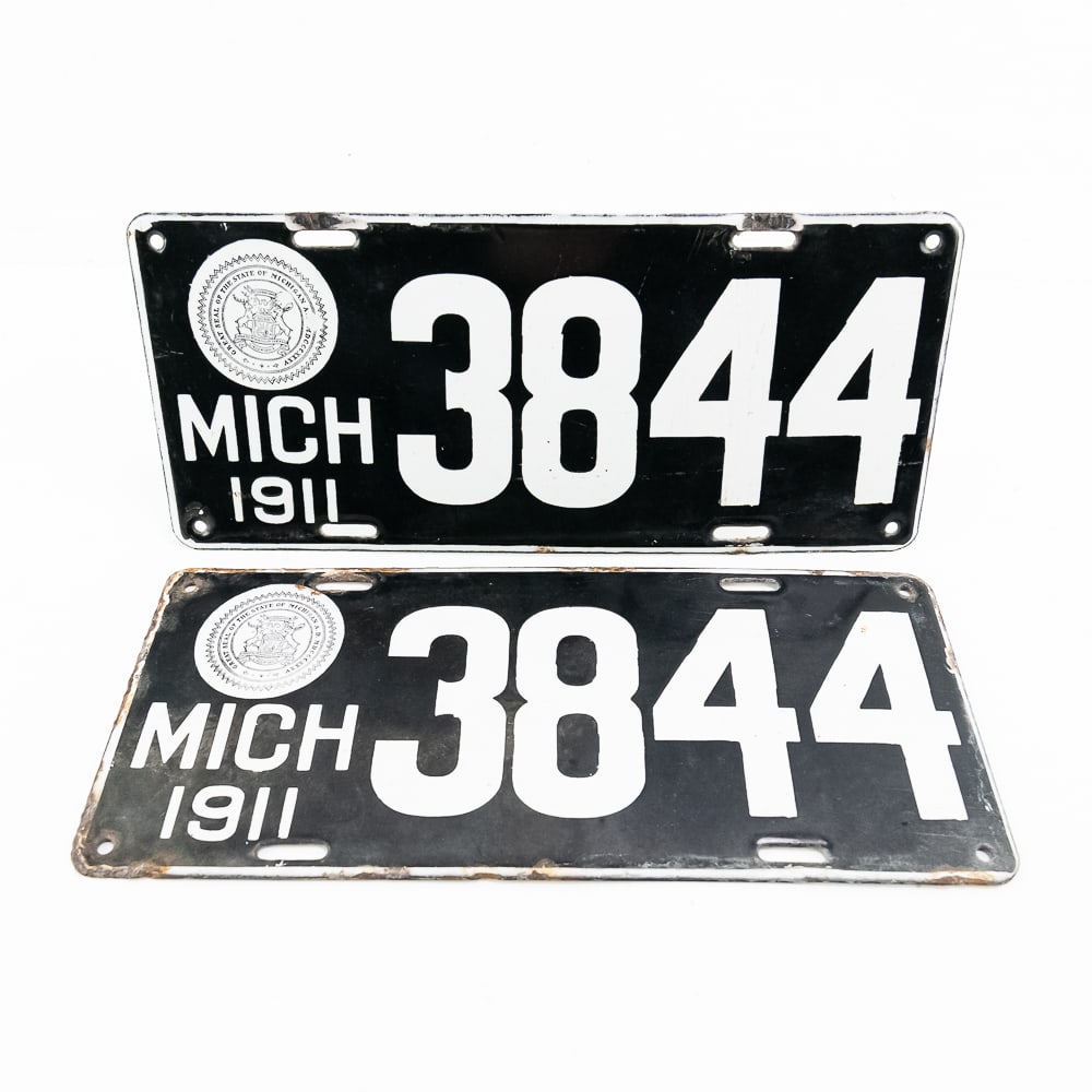 Michigan 1911 License Plate Pair: Michigan 1911 four digit porcelain pair in good+ original condition. One plate has porcelain chips at the top mounting holes and the other has minor edge chips with some rust and corrosion around the 