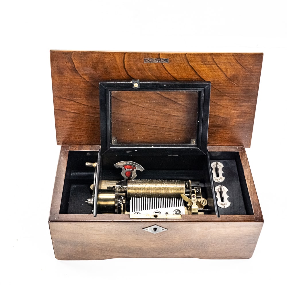 Antique Table Top Cylindrical Wood Music Box: Antique table top cylindrical wooden 29 comb tooth wooden music box featuring pull back winding handle. Winds and plays beautifully as expected with minor age and wear on case. 4"t x 6"d x 11.5"l. Per