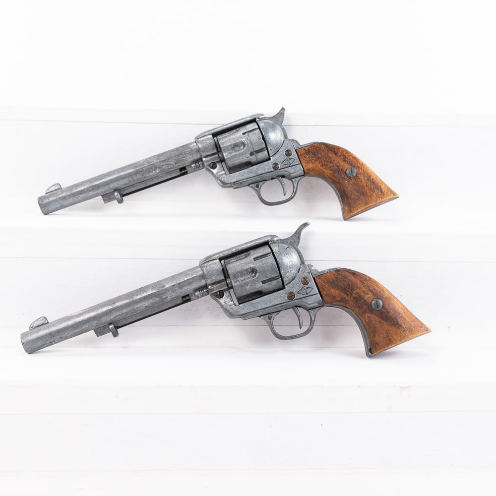 2 Denix Replica Colt 1873 SAA Revolvers: 2 Denix Made Replica Colt 1873 Single Action Army revolvers. Cast metal non-firing replica weapons are 7.5" barreled with wood grips. Excellent display pieces in good but used condition with some ding