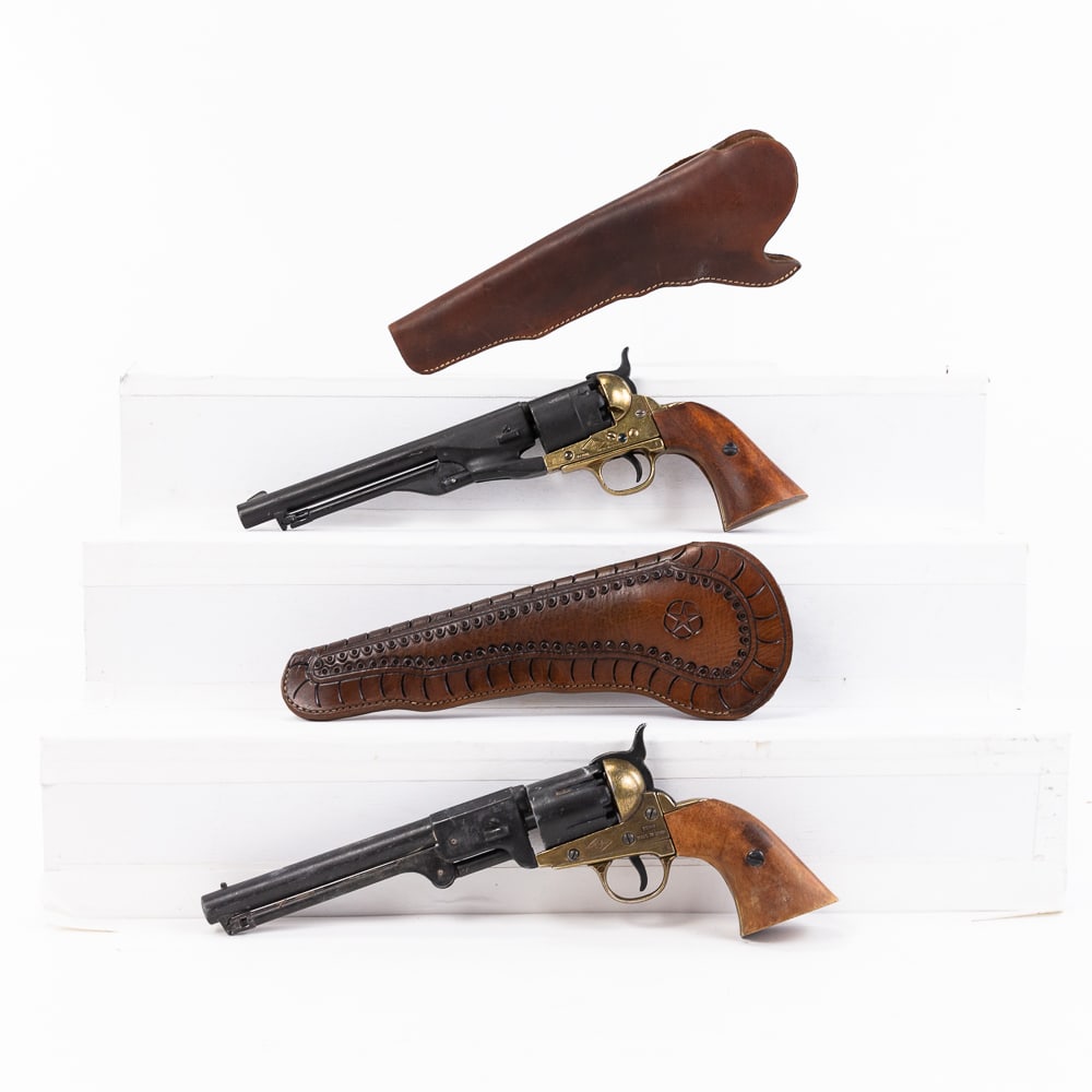 2 Denix Replica Colt Percussion Revolvers: 2 Denix Made Replica Colt percussion revolvers. Cast metal non-firing replica weapons are 7.5" barreled with wood grips and brass colored frames. Both guns come with high quality leather western belt 
