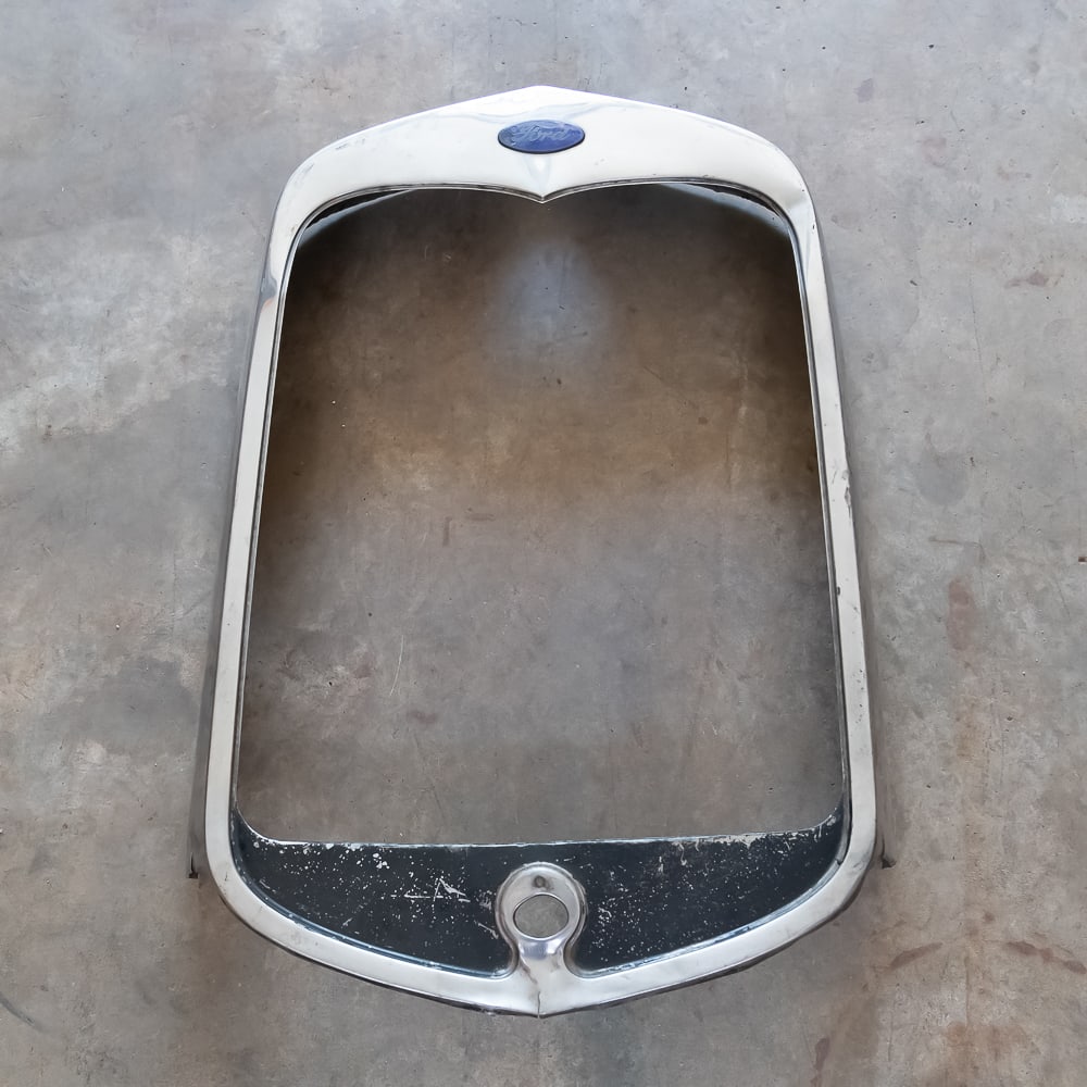 1930 Ford Model A Radiator Shell: Original, used stainless steel shell with Ford emblem - missing crank hole cover. In good condition with minor dents