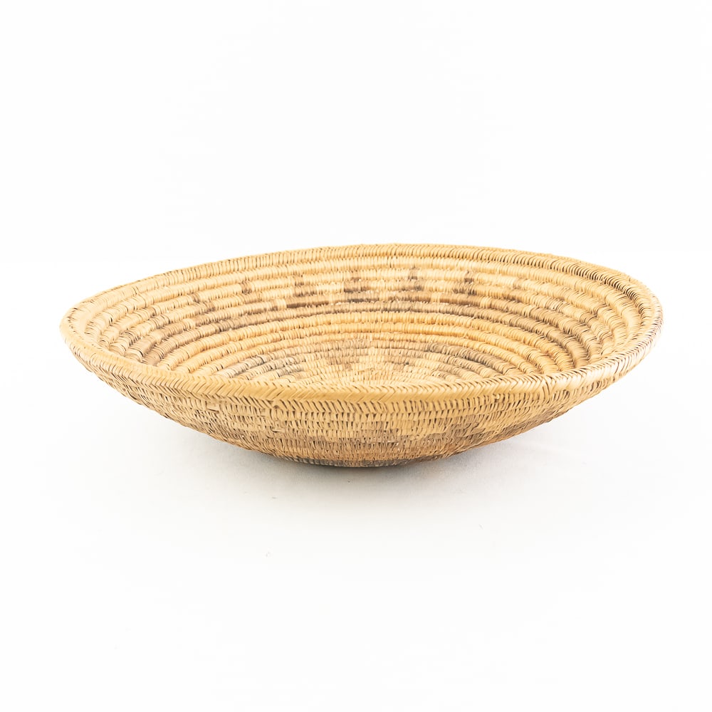 1940s Navajo Wedding Basket: Navajo wedding basket from the 1940s features a standardized and symbolic polychrome design described as a life chart mapping the Navajo world view. The center of this basket has an opening called rep