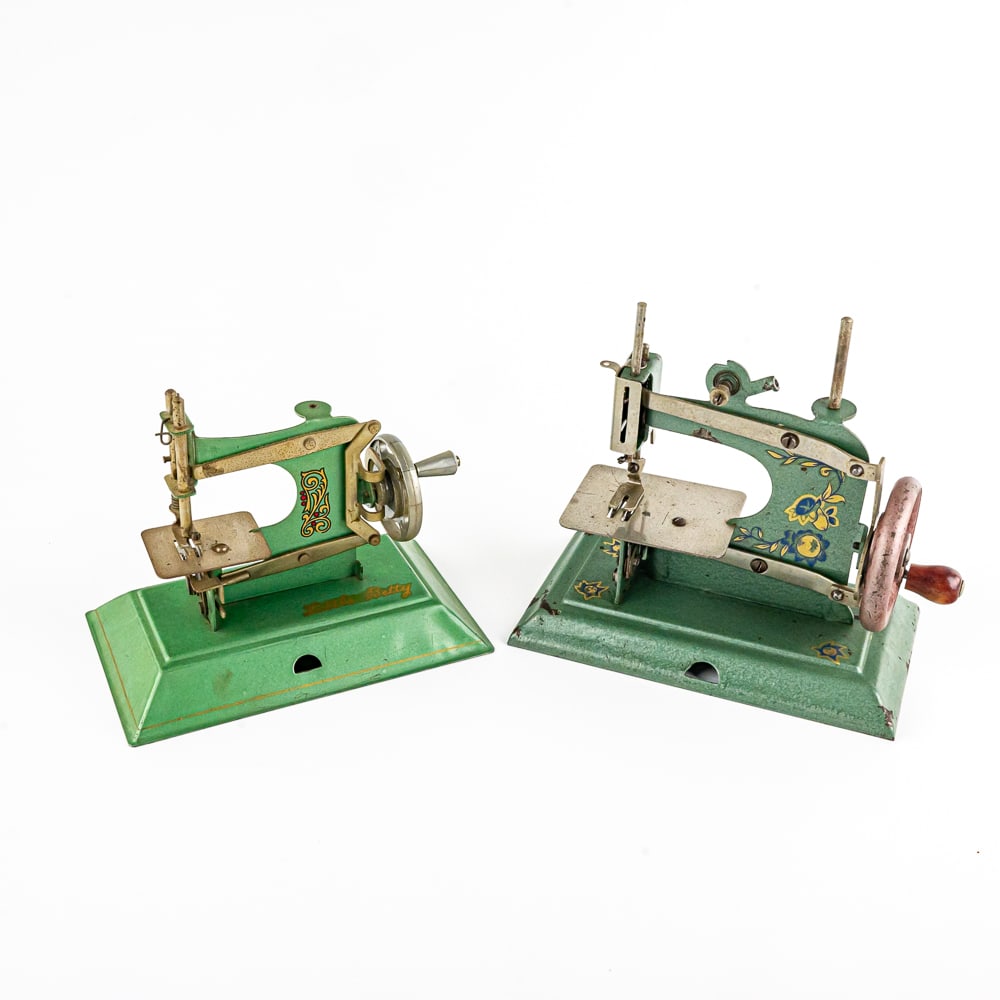 Vintage Little Betty & Schurhoff Sewing Machines: Vintage Little Betty & Schurhoff sheet metal bodied hand operated sewing machines. Each stands approximately 6" tall. Both are in good overall condition with some blemishes & imperfections, indicative