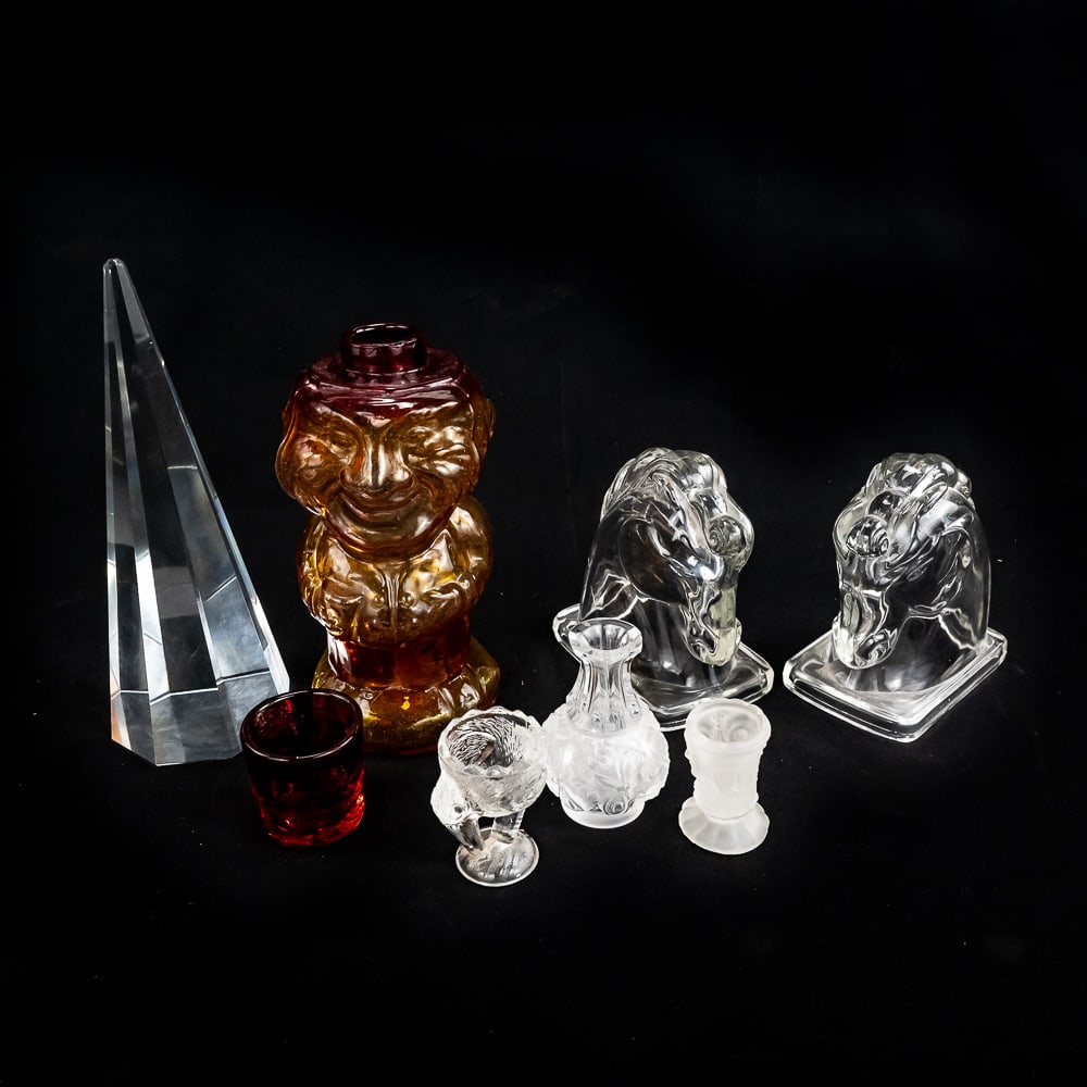 Assorted Crystal Glass Collection Decanter Pyramid: Collection showcases 10" (w shot glass) 70s Jolly Mountaineer Amberina decanter; 10" octagonal crystal pyramid obelisk (some light surface scratches); Pair of 5.5" art deco Horse Head glass bookends a
