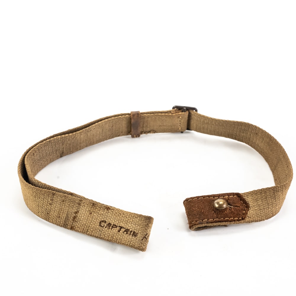 Original Japanese Arisaka Training Rifle Sling: Original World War II Japanese Arisaka training rifle canvas sling with leather keeper. The sling features the steel stud closure with a leather reinforcement tab. The canvas is in good condition,