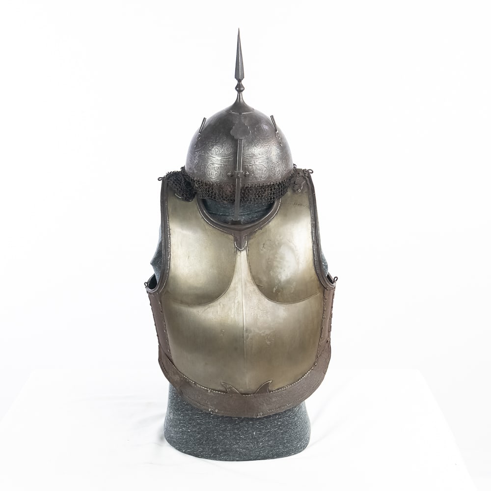 Indo-Persian Helmet and Damascus Steel Cuirass Set: This remarkable Indo-Persian armor set features a "Kulah Khud" helmet and a matching Damascus steel cuirass, likely originating from the 19th-century Qajar period. The helmet is a masterclass in