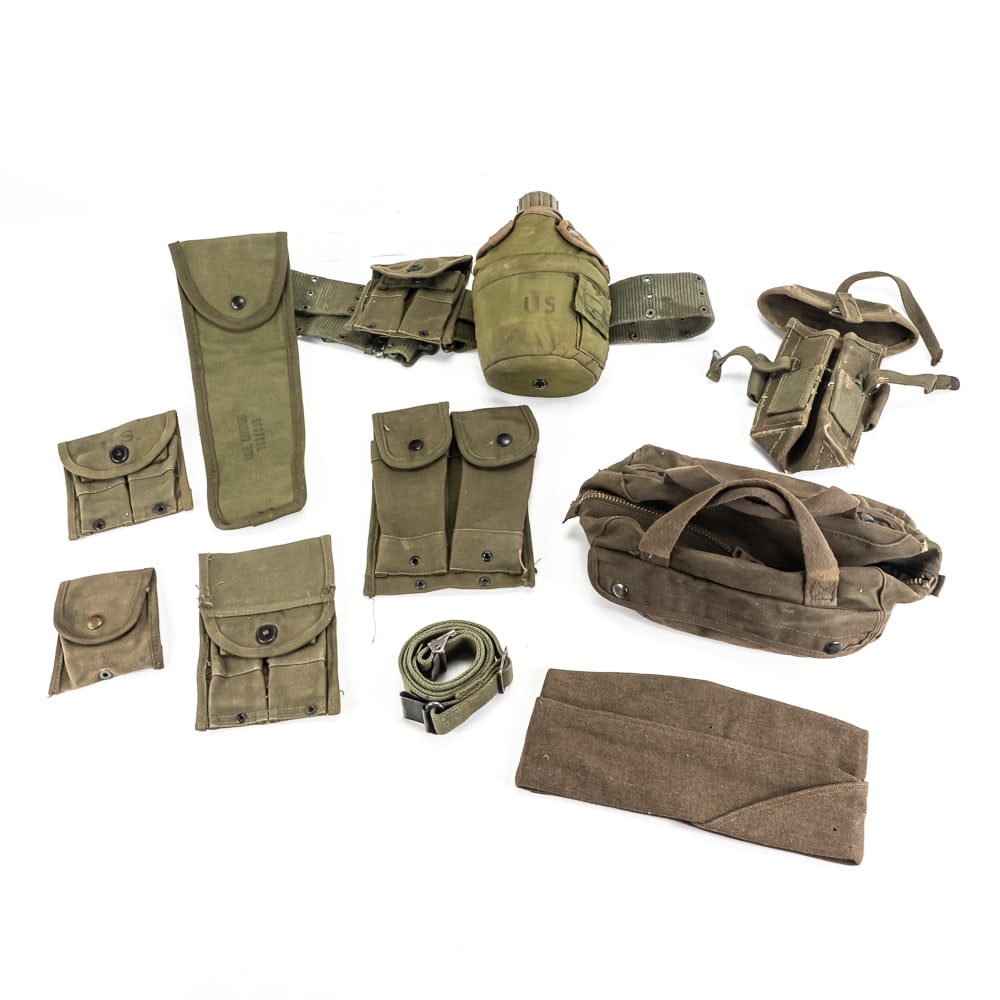 Post WWII US Field Gear Lot: Post WWII US military field gear lot. Lot includes 1950s dated overseas cap, 3 1950s dated M1 carbine magazine pouches, pistol belt with later canteen and cleaning rod pouch, compass pouch, military t