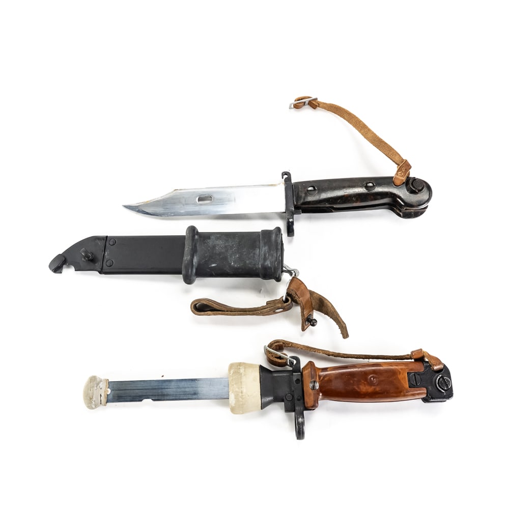 AKM Type Training and Combat Bayonets & Scabbards: Two classic Soviet-style bayonets are presented here, likely for the AKM rifle platform. One is an original brown plastic grip Type I Polish training bayonet, the other is black griped bayonet and