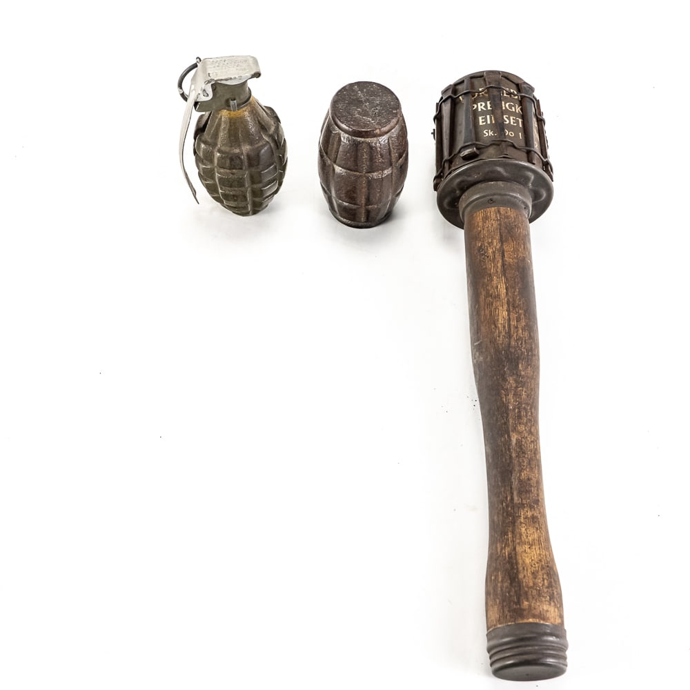 WWII Training Grenade Lot: 3 WW2 Training Grenades. 1 US MKII Pineapple style training grenade with holes cut in body for use with active fuses, German M24 "Potato Masher" stick Grenade. This appears to be a fired grenade handl