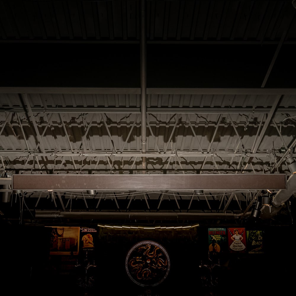 Industrial 12-Foot LED Ticker Main Theatre Lobby: This is a substantial industrial-grade LED electronic message center, commonly utilized in commercial settings, sports bars, or financial environments for real-time data streaming. The unit features a