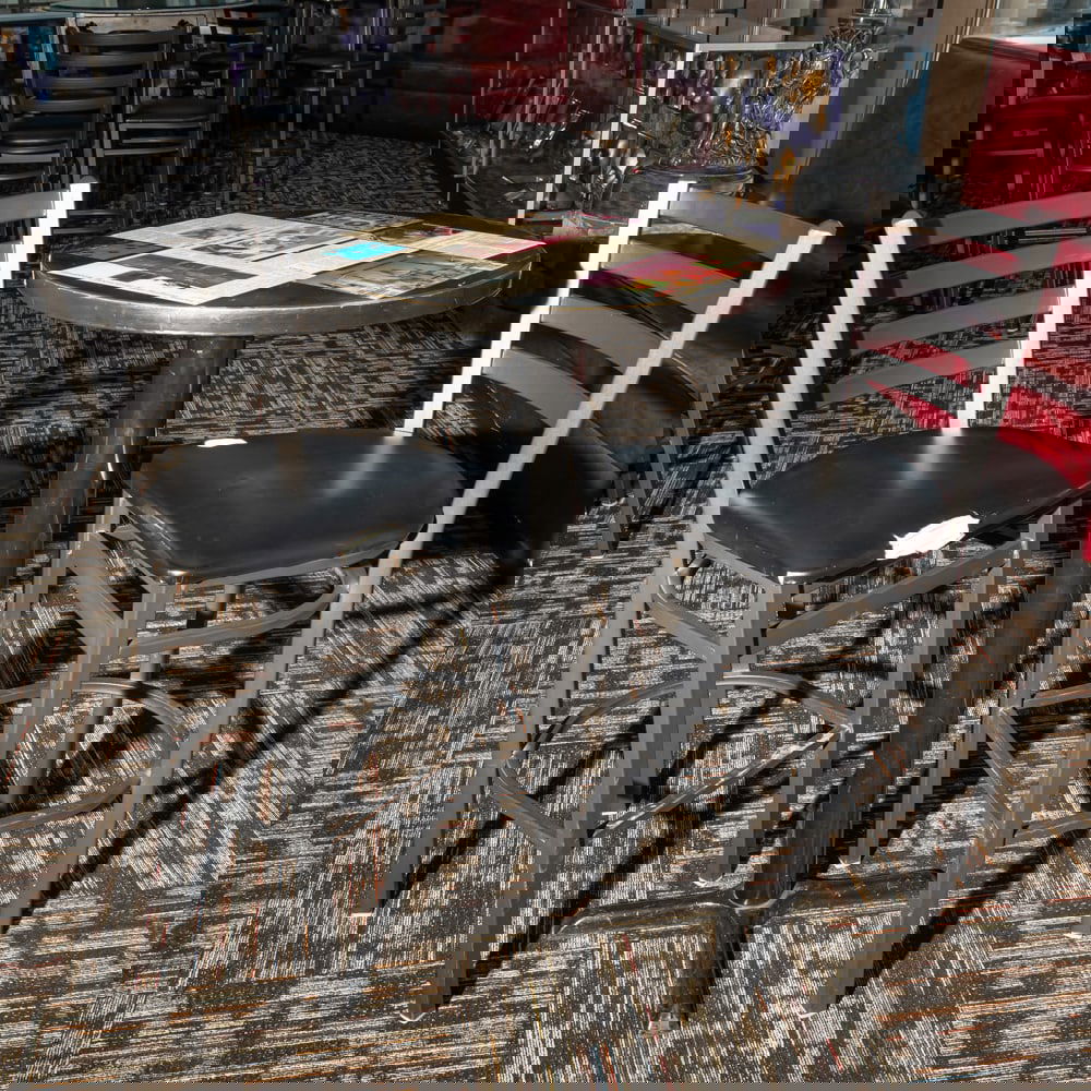 Cinema-Themed Bistro Table w/2 Chairs: This eye-catching bistro set features a round pedestal table topped with a collage of Hollywood-themed graphics, including classic cinema advertisements and "Hollywood" signage, capturing a mid-to-lat