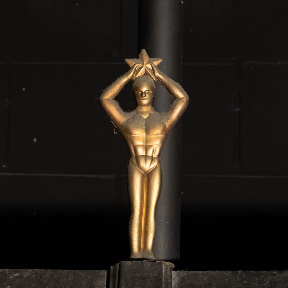 Movie Star Award Statue: Gold metal statue of a stylized Art Deco man holding a star above his head. Mounted on a 4" X 4" X 1" stone base. Measures 10" tall. Please use photos to judge condition and bid accordingly. Please no