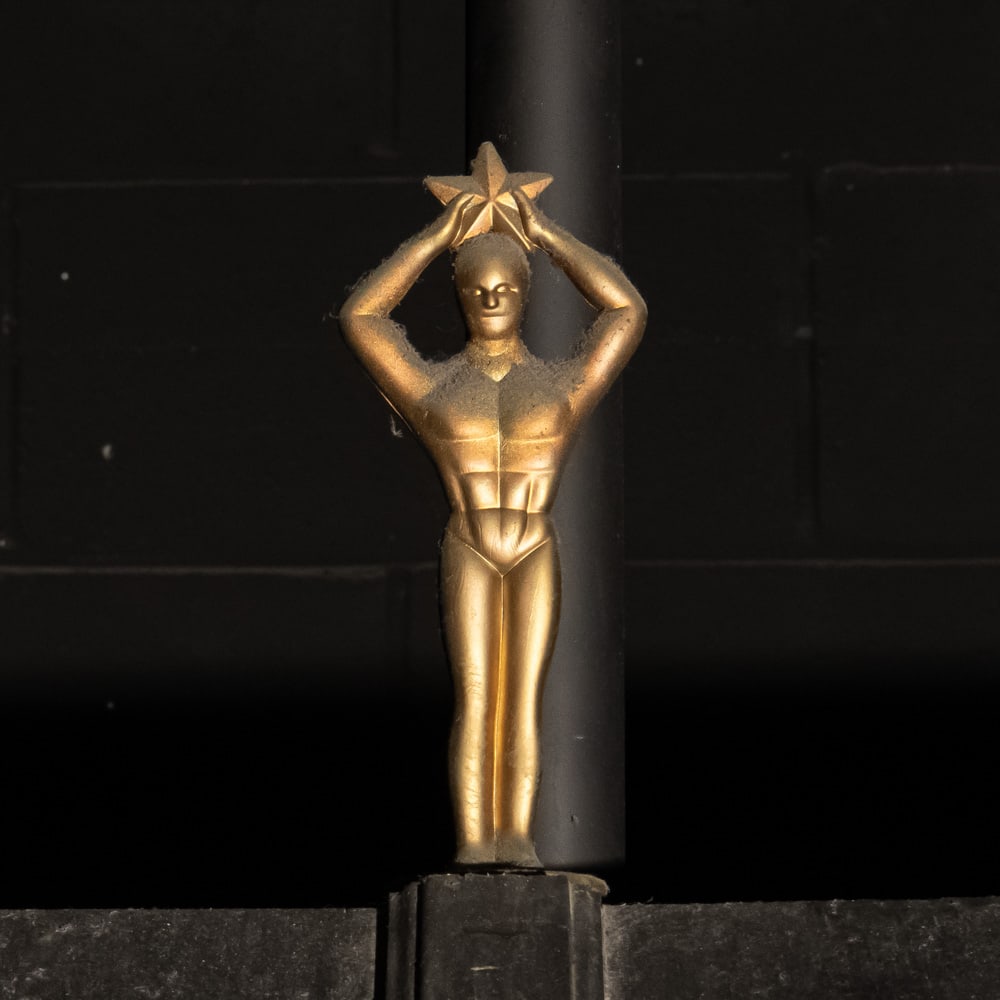 Movie Star Award Statue: Gold metal statue of a stylized Art Deco man holding a star above his head. Mounted on a 4" X 4" X 1" stone base. Measures 10" tall. Please use photos to judge condition and bid accordingly. Please no
