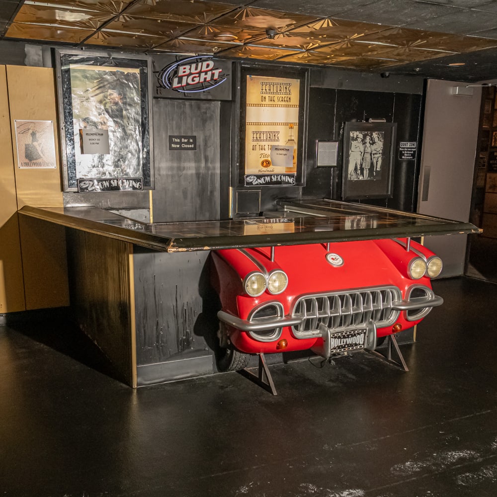 Custom Made 1958-62 Corvette Bar: U shaped, custom made wooden bar, featuring a front end of a 1958-1962 Corvette headlight and grille. Decoupage bar top with vintage scenes of Hollywood, in overall good condition - needs repainting.