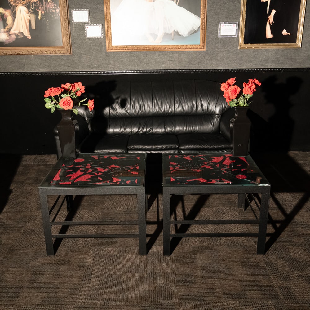 2 Matching Steel End Tables & Vases: 2 custom made matching steel end tables with movie theme cut out steel tops with glass tops. One glass top is broken. Tables come with a pair of 17" tall matching black vases. Tables measure 28" X 28"