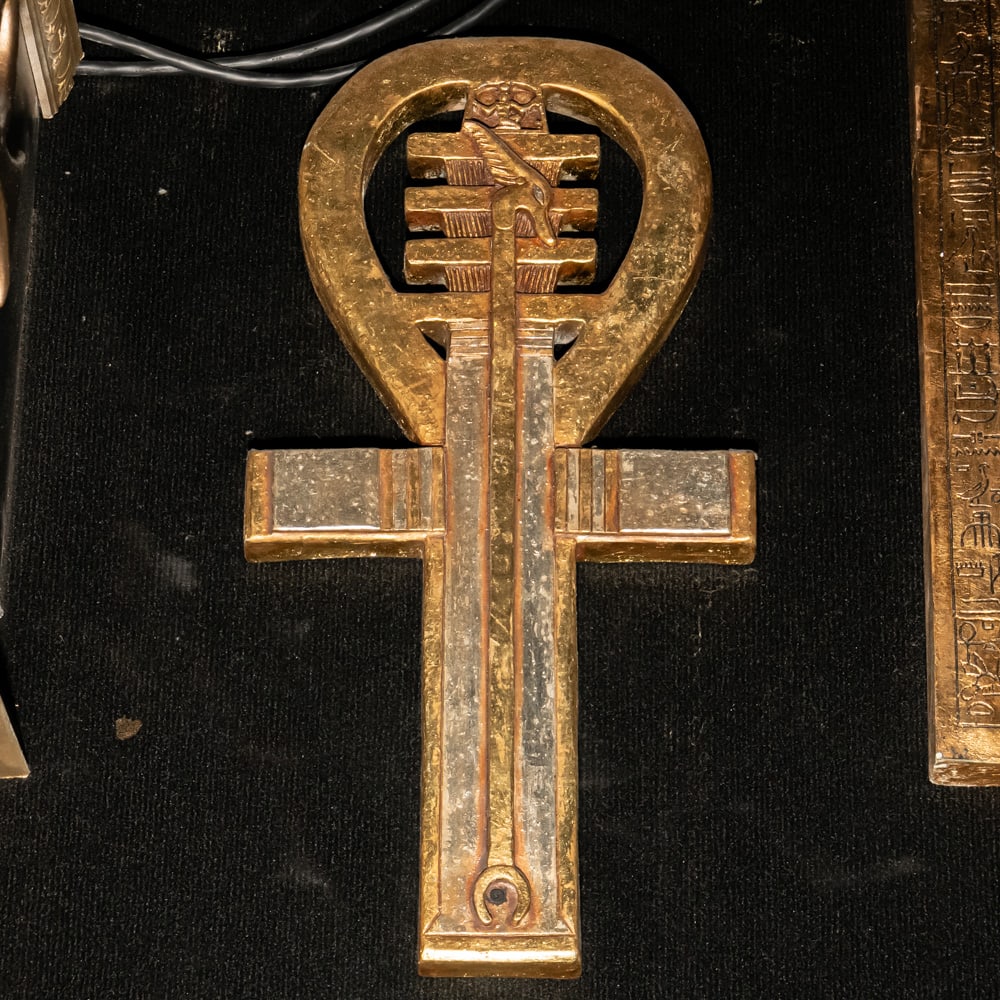 Ankn Symbol of Life - Right: This striking piece is a stylized Egyptian Ankh, a timeless symbol of life, rendered with a unique decorative flair that incorporates elements of the Djed pillar (stability) and the Was-scepter (power