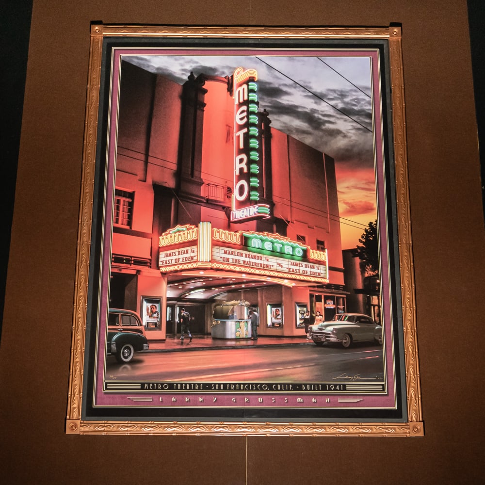 Larry Grossman Metro Theater Mural: Large mural print of the Metro Theater in San Francisco California 1941 by artist Larry Grossman. Mounted on foam core board in 2 panels with a decorative metal frame. Measures 8' tall, 6' wide. 