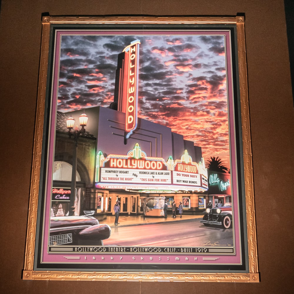 Larry Grossman Hollywood Theater Mural: Large mural print of the Hollywood Theater in Hollywood California 1919 by artist Larry Grossman. Mounted on foam core board in 2 panels with a decorative metal frame. Measures 8' tall, 6' wide. From