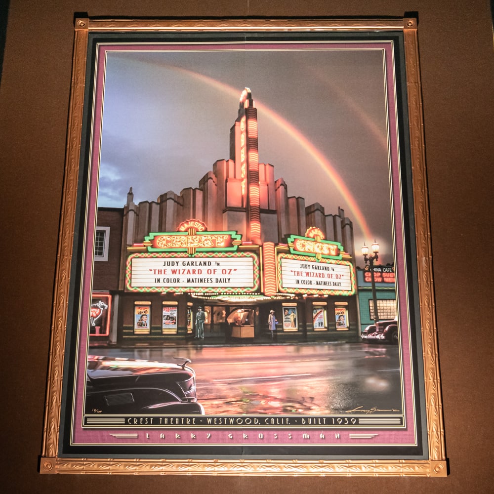 Larry Grossman Crest Theater Mural: Large mural print of the Westwood Village Theater in Westwood California 1931 by artist Larry Grossman. Mounted on foam core board in 2 panels with a decorative metal frame. Measures 8' tall, 6' wide.