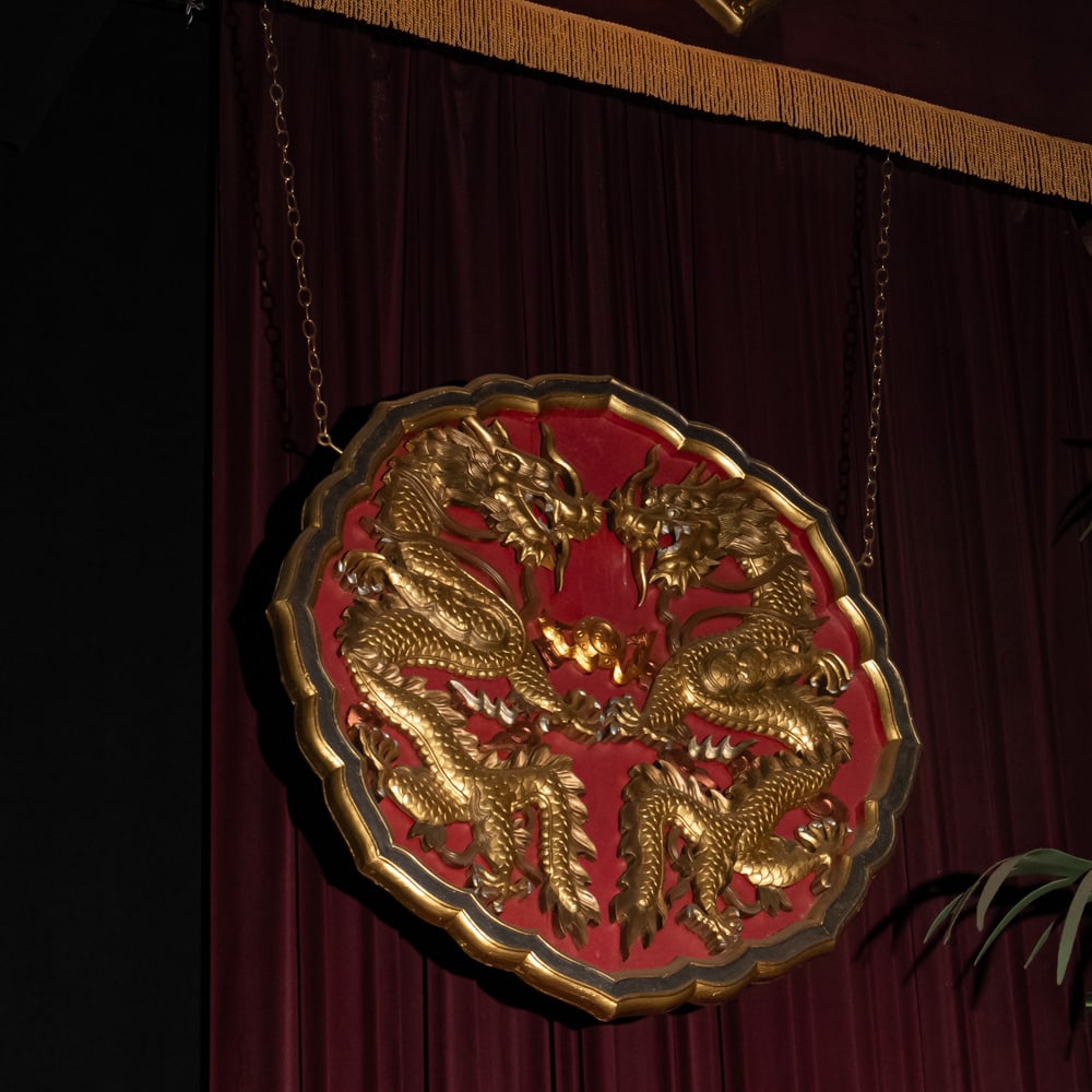 Ornate Hanging Gilded Chinese Dragon Plaque-R: This striking piece features two intricately carved, high-relief dragons in a confrontational "confronting the pearl" pose, a classic motif in Chinese art symbolizing power and wisdom. The dragons are