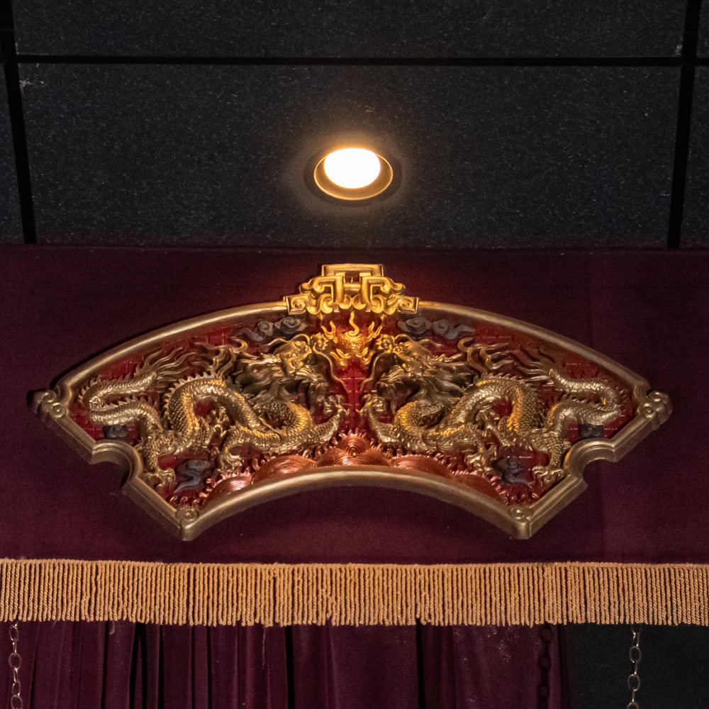 Ornate Gilded Dragon Fan Wall Decor (L): This striking piece of Chinoiserie features a relief-carved fan-shaped panel depicting two imperial dragons chasing a flaming pearl, a classic motif symbolizing power and good fortune. The intricate c