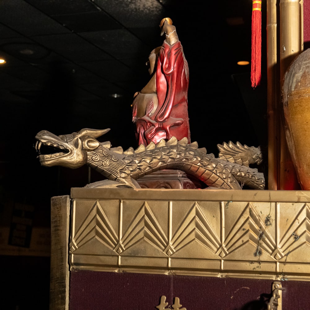 Carved Gilt Wood Oriental Dragon Figures Pair: Each carved wooden dragon features an elegant, serpentine form with a weathered gilt finish, likely originating from mid-20th century China or Southeast Asia. These pieces showcase traditional "Dongya