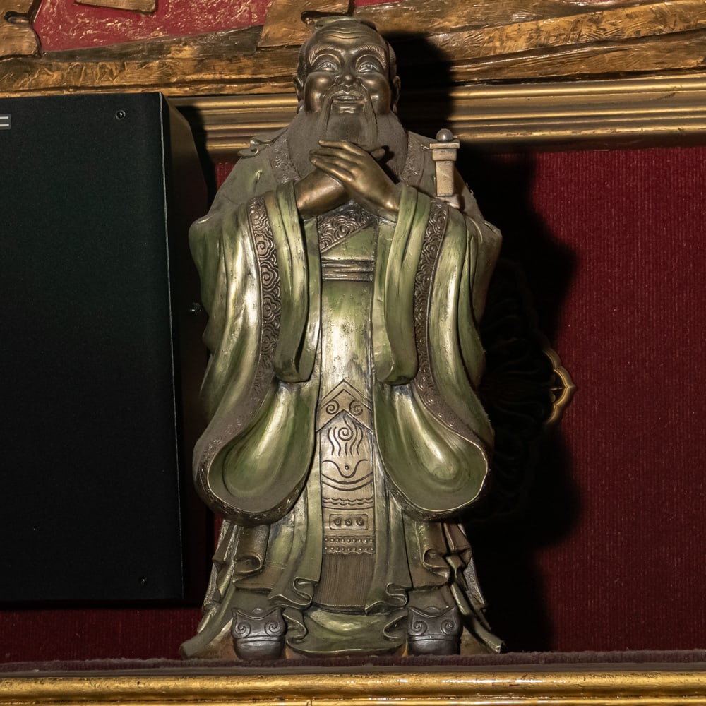 Confucius Style Gilded Scholar Statue: This striking figure captures the classic iconography of a Chinese scholar or sage, likely representing Confucius in a traditional pose of respect with hands clasped. The piece exhibits a Ming-style a