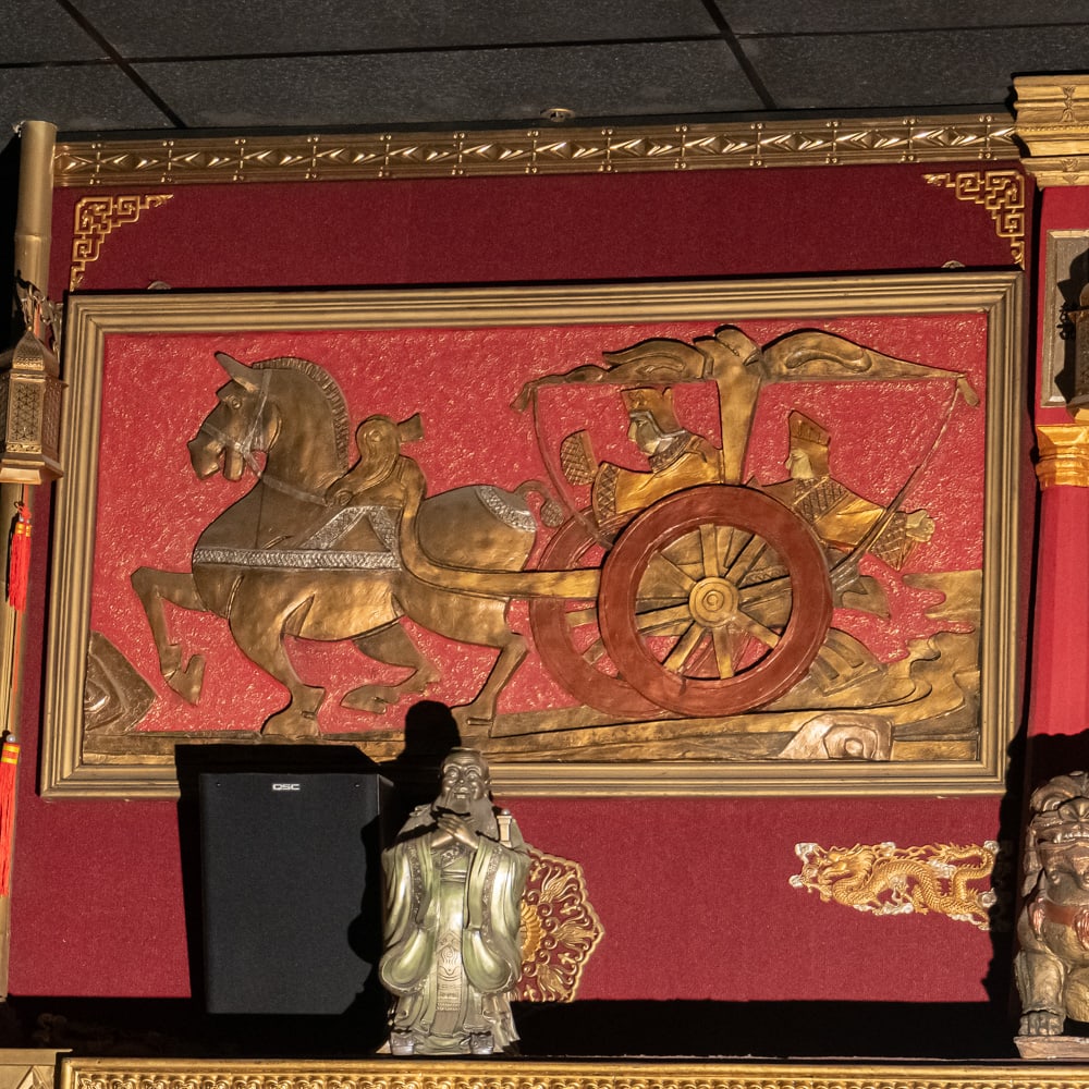 Chinese Gilt Chariot Relief Wall Art-Left: This striking piece of Chinoiserie features a high-relief carved panel depicting a traditional horse-drawn chariot with regal figures, finished in an opulent gold-tone gilt over a vibrant red textured