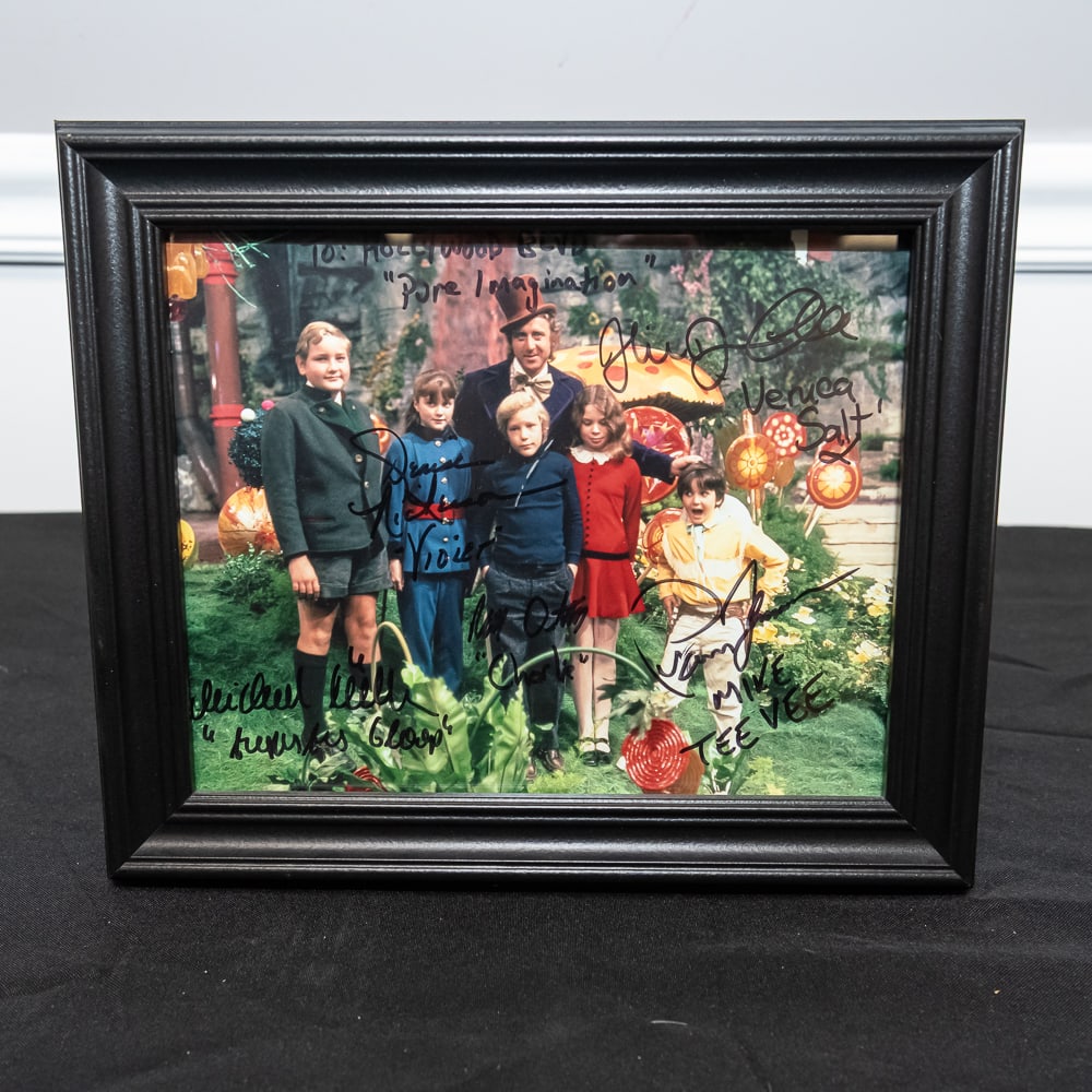 Framed Willy Wonka Cast Signed Photo 8x10: This is a fantastic collector's piece featuring a color still from the 1971 cinematic classic Willy Wonka & the Chocolate Factory, signed by the iconic cast. The piece includes the signatures of Gene