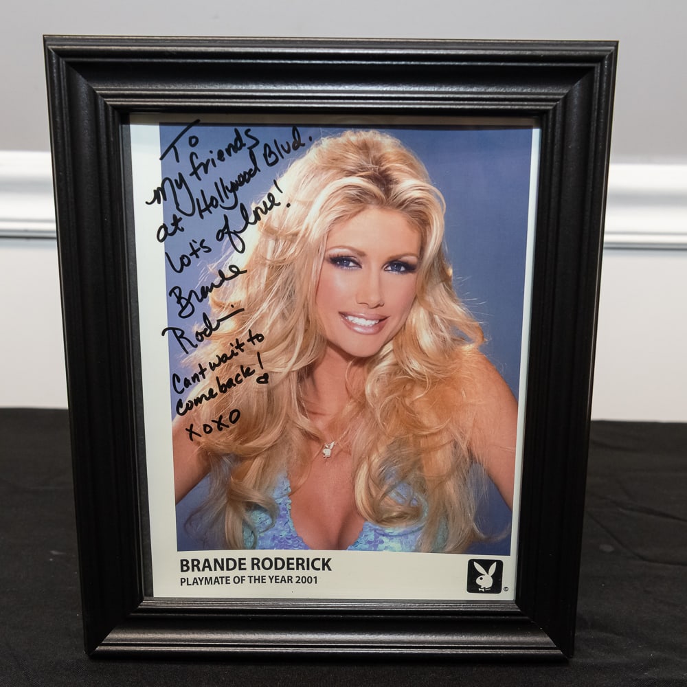 Framed Brande Roderick Signed Photo 8x10: This is a quintessential piece of early 2000s pop culture memorabilia featuring Brande Roderick, the 2001 Playboy Playmate of the Year and Baywatch star. The 8" x 10" color photograph is presented in