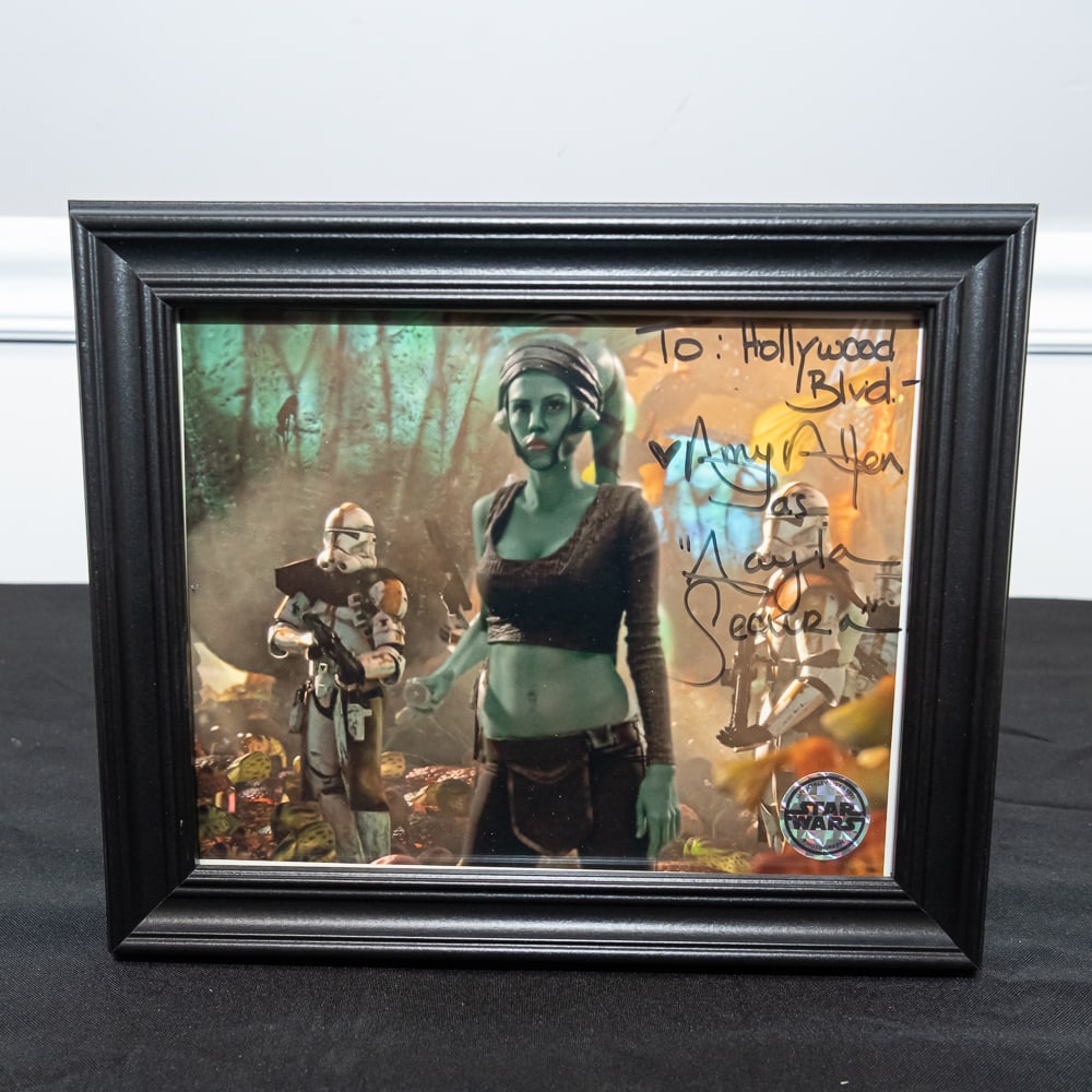 Signed Aayla Secura Star Wars Photo Framed 8x10: This is a fantastic piece of Star Wars memorabilia featuring a signed 8x10 color photograph of Jedi Master Aayla Secura, portrayed by actress Amy Allen. The photo depicts the iconic character on the f