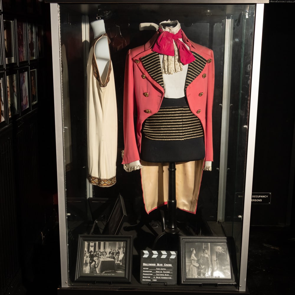 Tony Curtis Costume From The Purple Mask: Tony Curtis screen worn costume from the 1955 movie, The Purple Mask. In good condition. Comes with display torso, 2 framed studio photos from the movie, and a clapboard. Does not include display