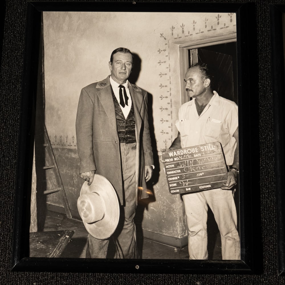 John Wayne Costume Still The Alamo: B&W photo costume still of actor John Wayne as Davy Crockett from the 1960 movie, The Alamo. Framed in good condition. Measures 21" tall x 17" wide. Please use photos to judge condition and bid